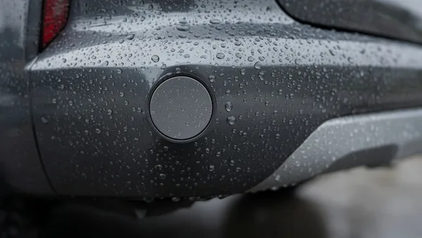 Foto close-up sensor parkir di bumper belakang dengan butiran air